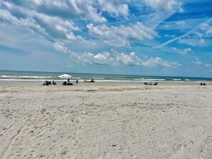 Una playa con una carpa y gente relajándose.