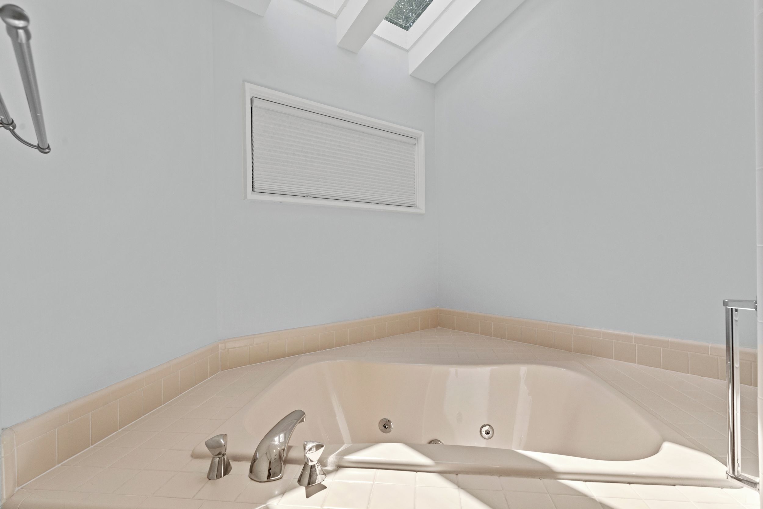 A modern bathroom with a freestanding bathtub, a shower area, and a skylight.