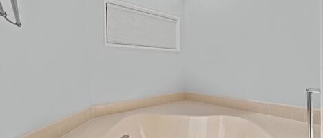 A modern bathroom with a freestanding bathtub, a shower area, and a skylight.