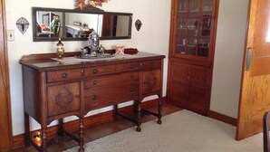 Een houten dressoir met spiegel en een kast met glazen deuren.