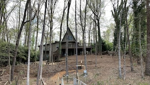 Une jetée en bois menant à un chalet entouré d’arbres.