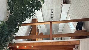 A spacious loft-style kitchen with a central island, wooden beams, and a dining area with a red table and chairs. - Cozy ski chalet 1/2 mile from Main Street, Great Location (Breckenridge)