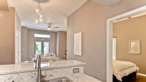 A modern kitchen with granite countertops, stainless steel sink, and pendant lighting.