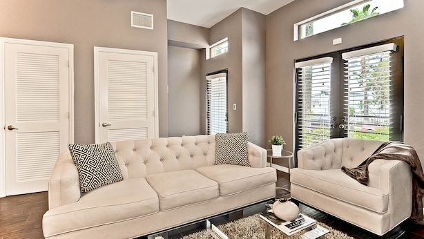 A living room with two beige sofas, a coffee table, and a side table with a plant.