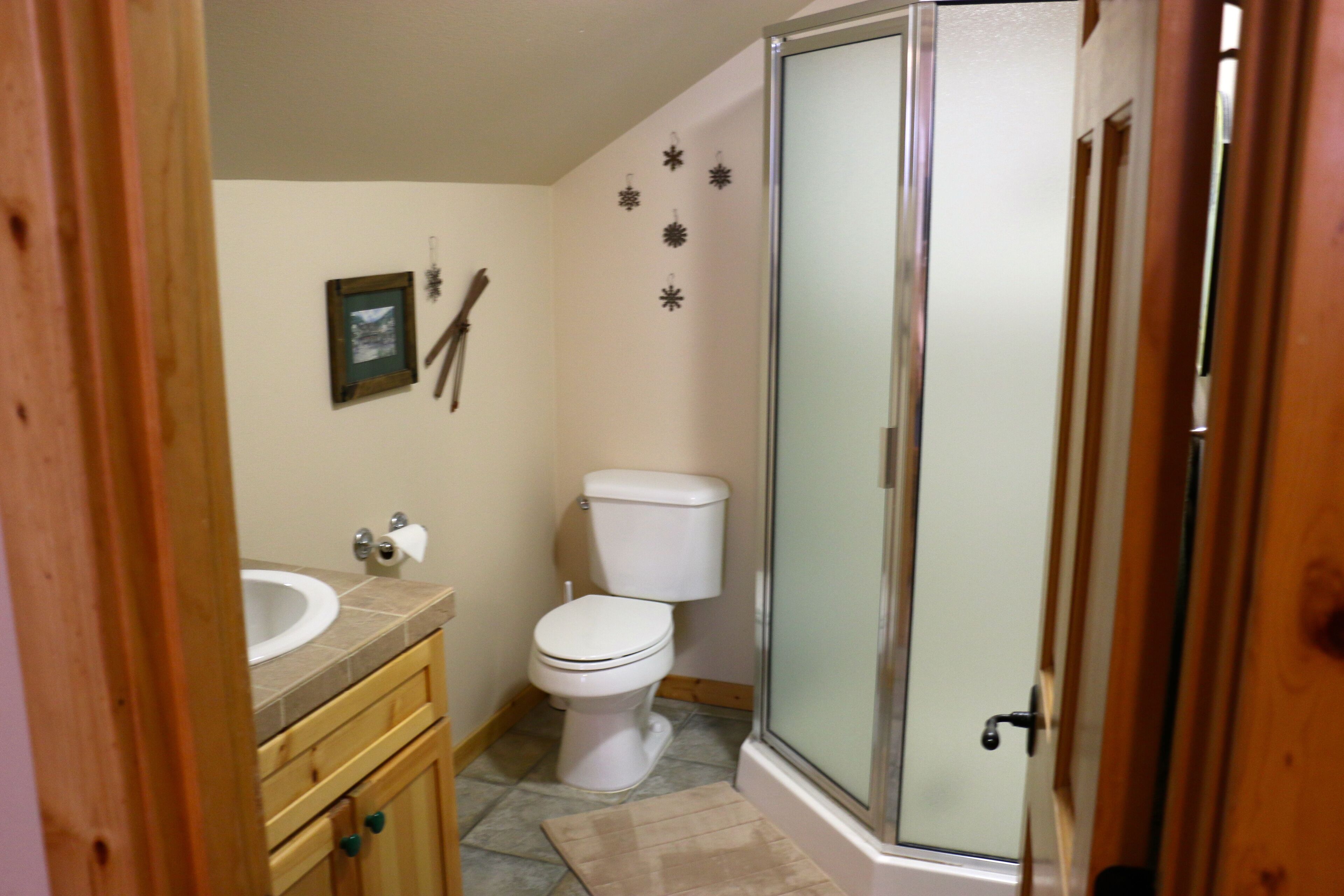 A bathroom with a toilet, sink, and shower.