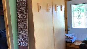 Una habitació amb un armari de fusta, una porta amb vitrall i un cartell amb les normes a la paret.