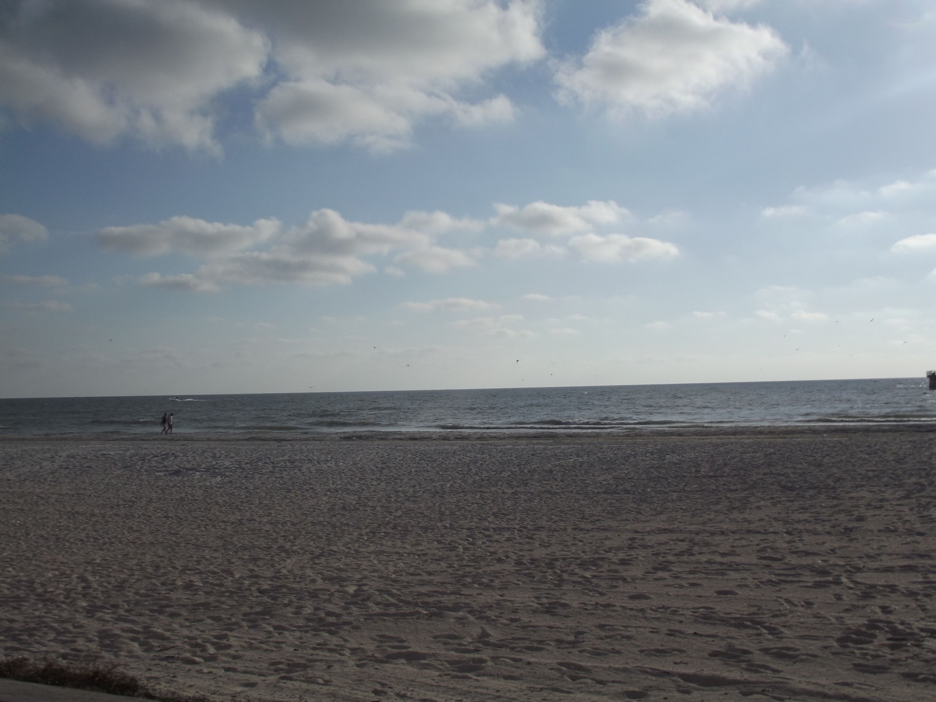 Una playa con cielo despejado y algunas nubes.