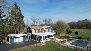 Une maison à deux étages avec un garage, un patio couvert et une cour arrière clôturée avec une piscine.