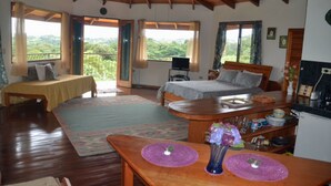 Ein gemütliches Schlafzimmer mit Bett, Schreibtisch und Blick ins Freie.