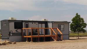A Catalina RV with a wooden deck and a small porch. - Catalina Park Model, in RV Ballard RV Park  (Thompson)