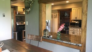 A kitchen with wooden cabinets, a stone countertop, and a vase with flowers. - LUXE Lodge 80ac. Huge pond cattle Ranch Views Close Nat Parks Ski McPhee (Dolores)