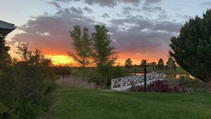 A sunset view over a grassy area with a white bridge and a body of water. - LUXE Lodge 80ac. Huge pond cattle Ranch Views Close Nat Parks Ski McPhee (Dolores)