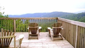 A wooden deck with Adirondack chairs and a table, overlooking a mountainous landscape. - Spectacular Mile High View,Free Wifi-Pool-Smart Tvs-W&D-Gym-No hidden fees ! (Banner Elk)