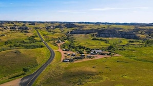 Un paysage rural avec une route sinueuse, des champs verdoyants et des bâtiments dispersés.