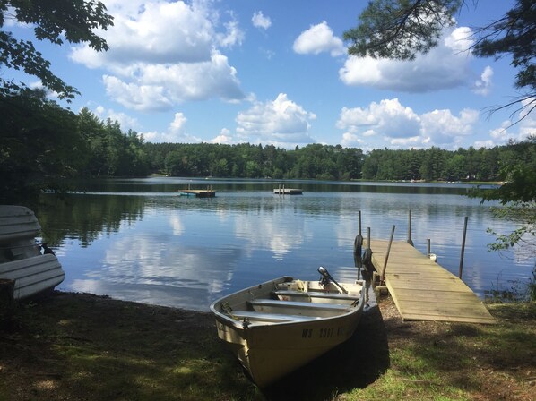 Ein ruhiger See mit einem Steg und einem kleinen Boot.