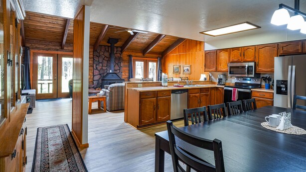 A spacious kitchen with wooden cabinets, a central island, and modern appliances. - COZY CABIN IN COUNTRY CLUB WITH FOREST VIEWS-PETS WELCOME! (Pinetop)