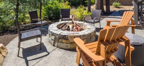 A stone fire pit surrounded by outdoor furniture.