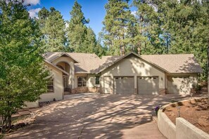 Surrounded by a well-maintained lawn and trees, this single-story house offers a serene and environment.