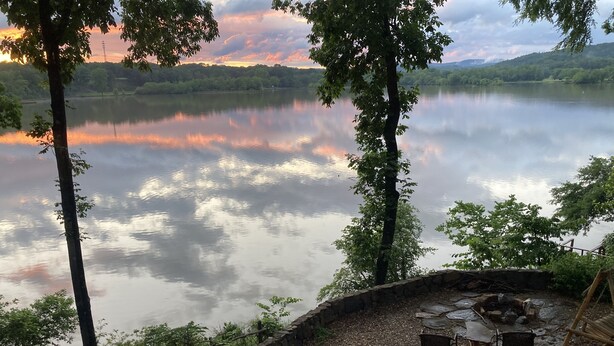 A lakeside view with a stone wall, a fire pit, and two chairs. - Secluded getaway on Lake Catherine, minutes from town - birds, fishing, & kayaks (Hot Springs)
