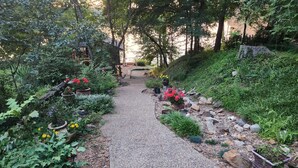 A garden pathway with potted plants and flowers. - Secluded getaway on Lake Catherine, minutes from town - birds, fishing, & kayaks (Hot Springs)