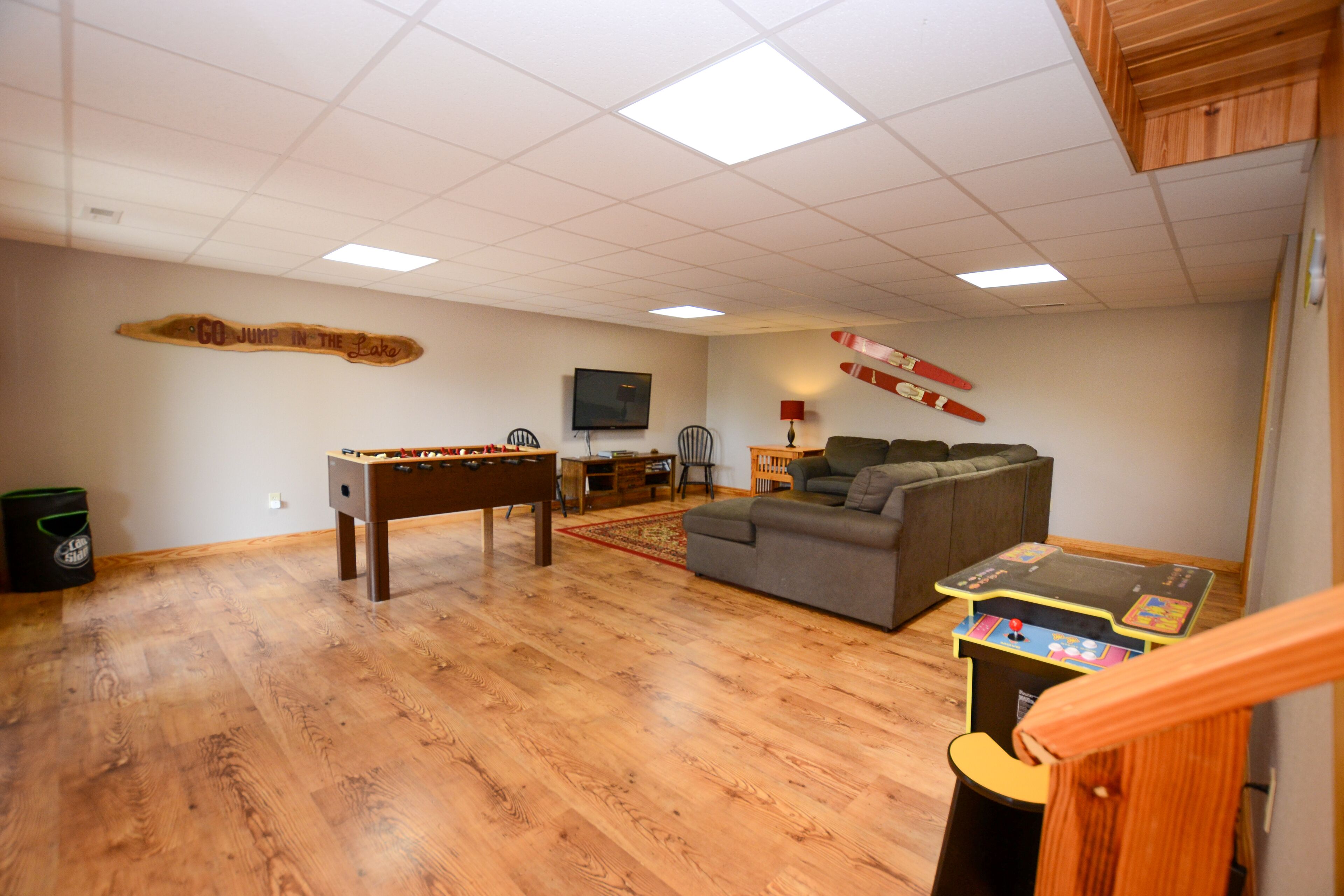 Een ruime woonkamer met een tafelvoetbaltafel, een bank en een pooltafel.
