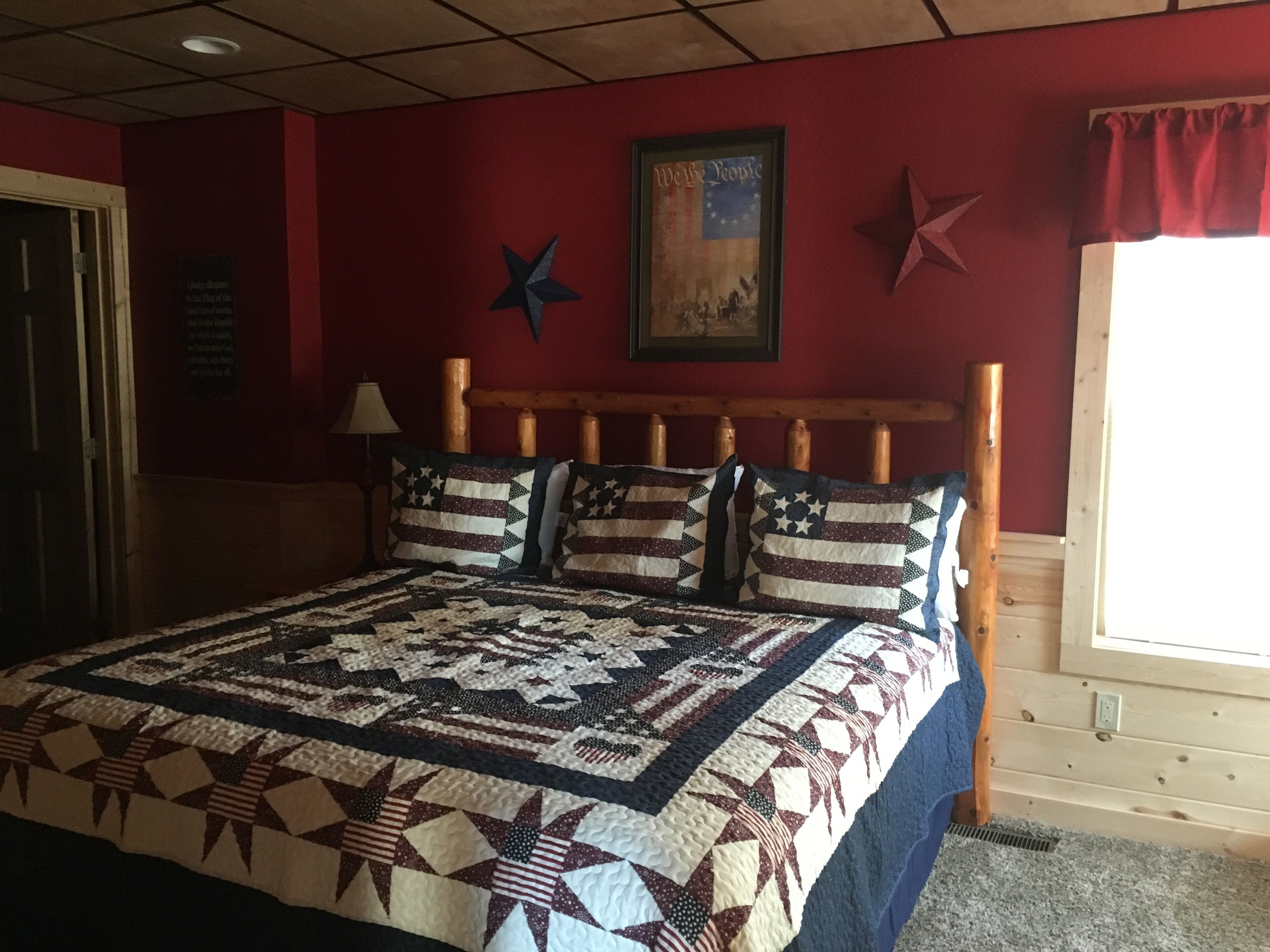 A bedroom with a wooden headboard, a quilted bedspread, and star-shaped pillows.
