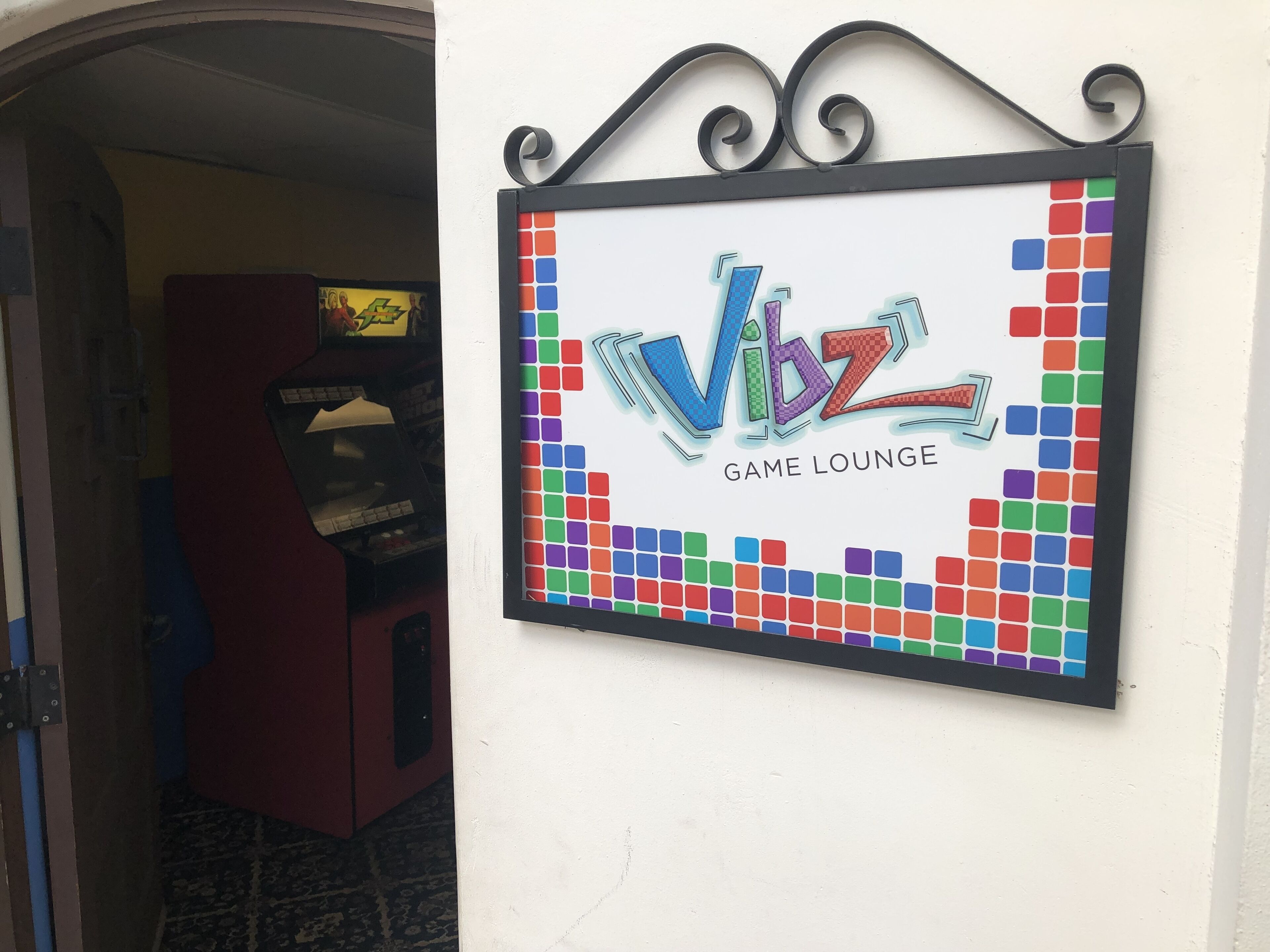 A sign for 'Vibz Game Lounge' with a colorful, pixelated design.