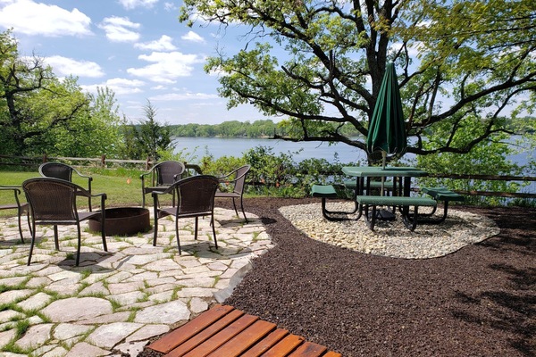 Brand new stone patio with campfire and lounging area for summer 2026!