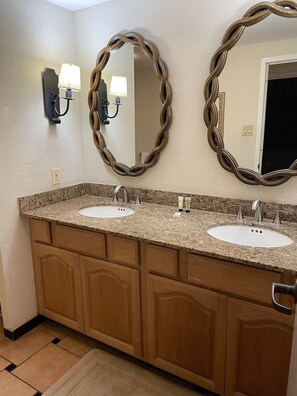 A bathroom with two sinks, wooden cabinets, and a large mirror with a twisted frame. - LOCATION! Beach & Ocean Front Luxury Villa Rio Mar Resort (Rio Grande)