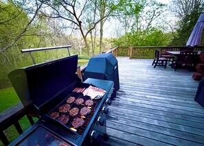 A barbecue grill with hamburgers on a wooden deck. - Bourbon Trail Cabin Game Room, Pond, Fire Pit & Ark Encounter (Bagdad)