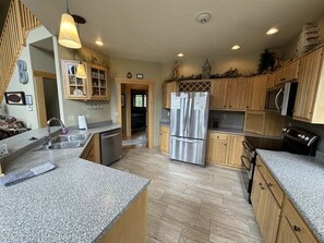 A kitchen with granite countertops, stainless steel appliances, wooden cabinets, and a built-in oven.
