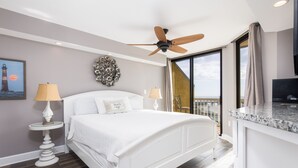 A modern hotel room with a large bed, ceiling fan, and a view of the ocean. - Stay @ Villa Carolina on Folly Beach (Folly Beach)