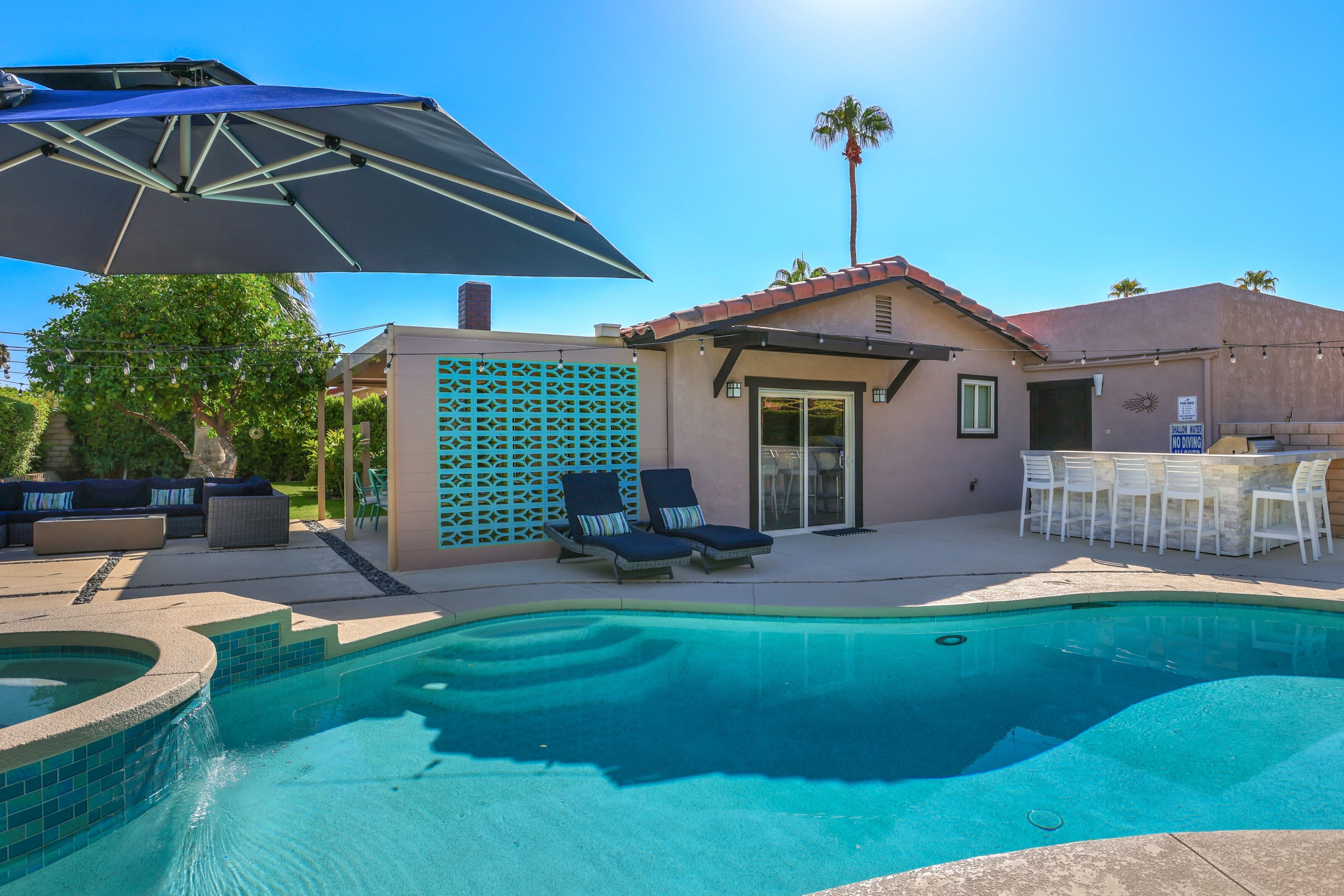 Un jardin avec une piscine, du mobilier d’extérieur et un espace patio.