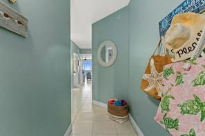 Un corridoio con una parete azzurra tenue, uno specchio rotondo e una insegna fissata al muro.