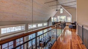 Un loft espaiós amb sòl de fusta, un balcó amb barana i grans finestres que donen vistes a l'exterior.