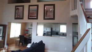 A spacious living room with a high ceiling, a dining area, and a kitchen. - Ocean Retreat -  Rustic style house  w/pool, Pet Friendly.  (Rehoboth Beach)