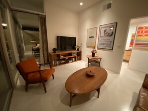 A modern living room with a TV, a wooden coffee table, and a sofa.