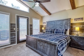 A bedroom with a bed, a nightstand, a lamp, and a ceiling fan. - Family Getaway Close to Parkway-w/ Theater and Game Room (Pigeon Forge)