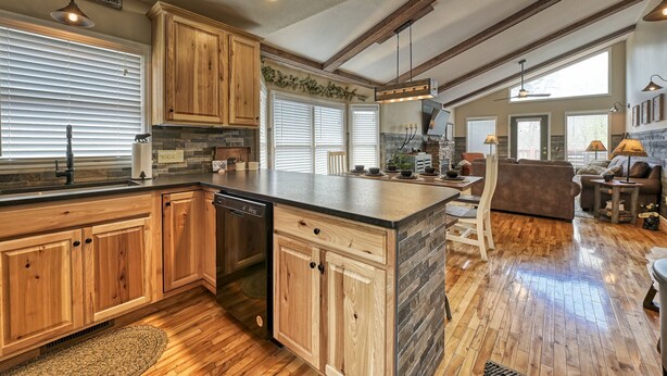 A spacious kitchen with wooden cabinets, a dishwasher, and a large island. - Family Getaway Close to Parkway-w/ Theater and Game Room (Pigeon Forge)