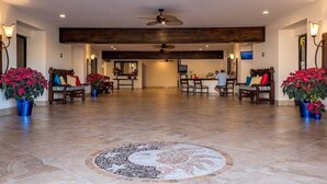 A spacious lobby with a central seating area, multiple ceiling fans, and potted plants. - Good Value Cabo Condo with Pool at Marina Sol. Walk to Beach, Bars!! (Cabo San Lucas)