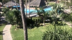 A resort with a pool, palm trees, and a building with multiple balconies. - Good Value Cabo Condo with Pool at Marina Sol. Walk to Beach, Bars!! (Cabo San Lucas)