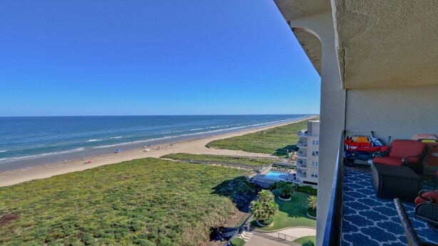A balcony with a view of a beach and ocean.