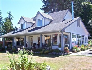 Stunning two-story home with a gable roof, covered porch, and beautifully maintained yard.