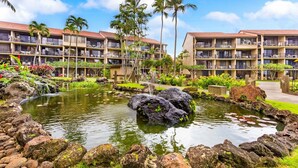 A hotel with multiple floors, outdoor pools, and lush landscaping.