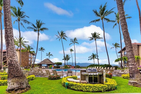 A resort with a pool, lounge chairs, and palm trees. - Papakea RESORT! - RENOVATED unit, GROUND FLOOR & steps to BEACH, POOL & BBQ
(Lahaina)