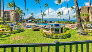 A resort with a pool, lounge chairs, and palm trees.
