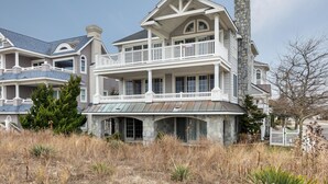 A two-story house with a stone facade, a balcony, and a chimney.