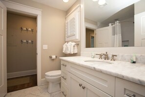 Un baño con inodoro, lavabo y espejo.