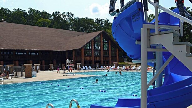 Una piscina con uno scivolo acquatico e lettini.