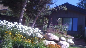 A landscaped garden with various flowers and rocks in front of a building.